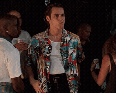 A Man In A Colorful Shirt Is Standing In A Crowd Of People GIF