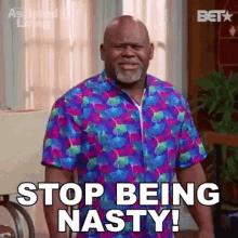 A Man In A Colorful Shirt Is Standing In A Living Room And Saying `` Stop Being Nasty ! '' GIF