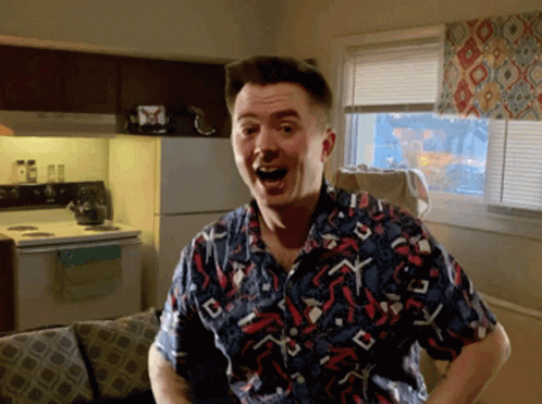 A Man In A Colorful Shirt Stands In A Kitchen GIF