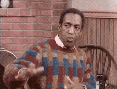 A Man In A Colorful Sweater Is Sitting At A Table With A Wheelchair . GIF