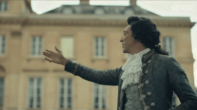 A Man In A Costume Is Standing In Front Of A Building With Netflix Written On The Bottom Of The Screen GIF