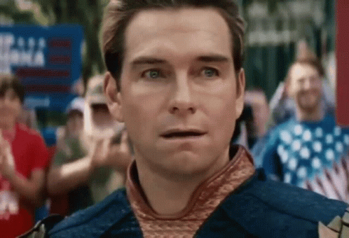 A Man In A Costume Is Standing In Front Of A Crowd Of People . GIF