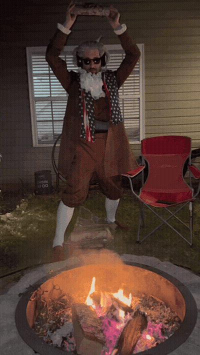 A Man In A Costume Is Standing In Front Of A Fire Pit GIF