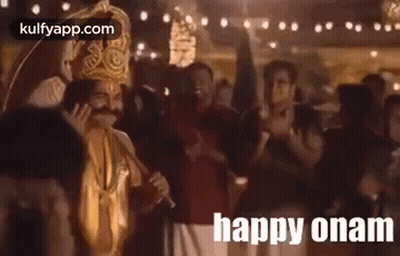 A Man In A Costume Is Waving At A Crowd Of People While Holding A Microphone . GIF
