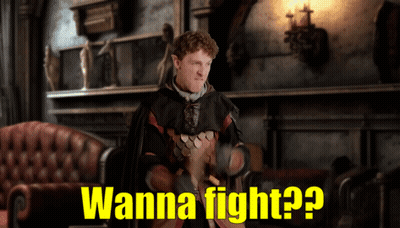 A Man In A Costume Says " Wanna Fight " In A Room GIF