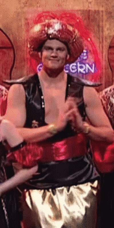 A Man In A Costume Stands In Front Of A Neon Sign That Says Corn GIF