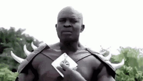 A Man In A Costume With Horns Is Holding A Piece Of Paper . GIF
