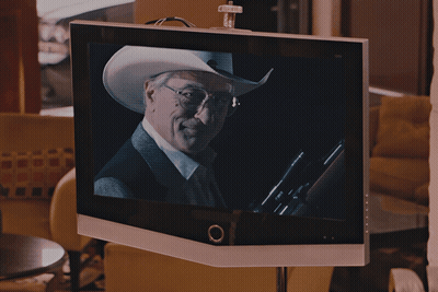 A Man In A Cowboy Hat And Glasses Is On A Television Screen GIF