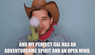 A Man In A Cowboy Hat And Scarf Says " And My Perfect Gal Has An Adventursome Spirit And An Open Mind " GIF