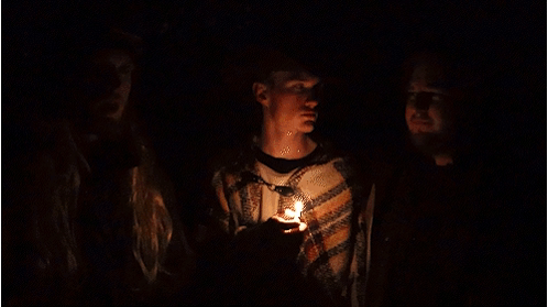 A Man In A Cowboy Hat Holds A Candle In His Hand GIF
