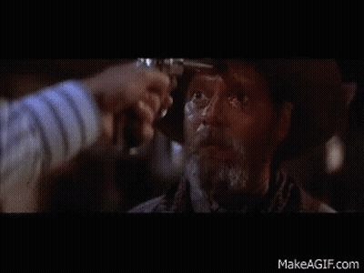 A Man In A Cowboy Hat Is Being Shot By Another Man With A Gun GIF