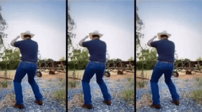 A Man In A Cowboy Hat Is Dancing In A Dirt Field GIF