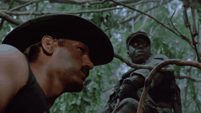 A Man In A Cowboy Hat Is Looking At Another Man GIF