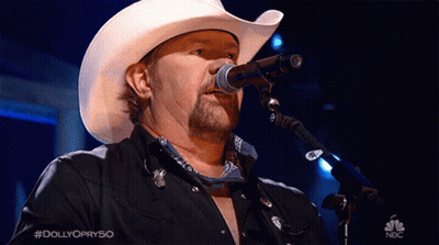 A Man In A Cowboy Hat Is Singing Into A Microphone On Nbc GIF