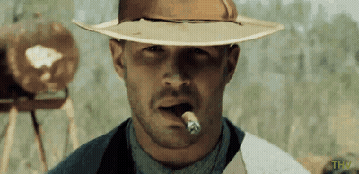 A Man In A Cowboy Hat Is Smoking A Cigar With The Letters Thw Below Him GIF