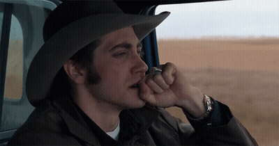 A Man In A Cowboy Hat Is Smoking A Cigarette In A Car GIF