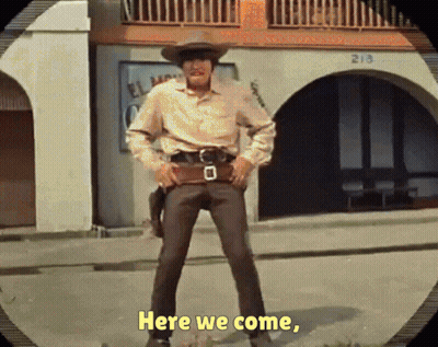 A Man In A Cowboy Hat Is Standing In Front Of A Building That Says 213 On It GIF