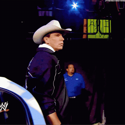 A Man In A Cowboy Hat Is Standing In Front Of A Summer Slam Sign GIF