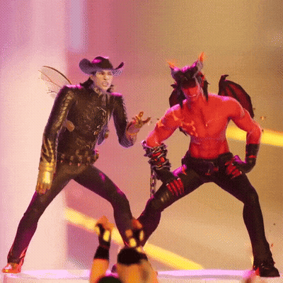 A Man In A Cowboy Hat Is Standing Next To A Devil With Horns GIF