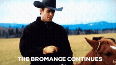 A Man In A Cowboy Hat Is Standing Next To A Horse In A Field With The Words " The Bromance Continues " Above Him GIF