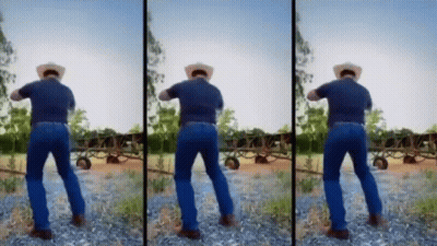 A Man In A Cowboy Hat Is Standing On A Rocky Field . GIF