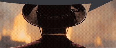 A Man In A Cowboy Hat Stands In Front Of A Large Fire GIF