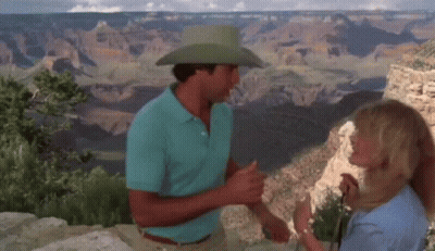 A Man In A Cowboy Hat Talks To A Woman GIF