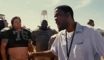 A Man In A Crop Top With The Number 76 On It Is Talking To Another Man In A White Shirt . GIF