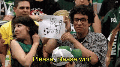A Man In A Crowd Holds Up A Drawing Of A Cat And Says Please Please Win GIF