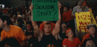 A Man In A Crowd Holds Up A Sign That Says Season Start GIF