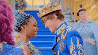 A Man In A Crown Is Standing Next To A Woman In A Blue Dress And Looking At Her . GIF