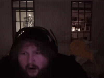 A Man In A Dark Room With A Christmas Tree In The Background Says Genius GIF