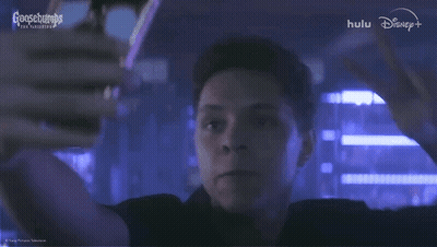 A Man In A Dark Room With A Goosebumps Logo In The Background GIF