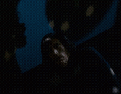 A Man In A Dark Room With A Star Projected On The Wall Behind Him GIF