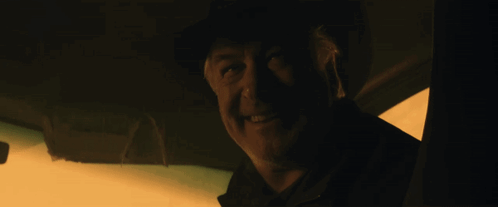 A Man In A Dark Room With His Mouth Open And His Tongue Sticking Out GIF