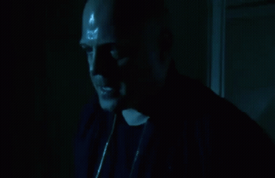 A Man In A Dark Room With Sweat Coming Out Of His Forehead GIF