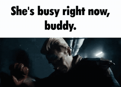 A Man In A Dark Room With The Words She 'S Busy Right Now Buddy Above Him GIF