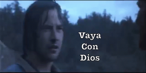 A Man In A Dark Room With The Words " Vaya Con Dios " On The Bottom Right GIF