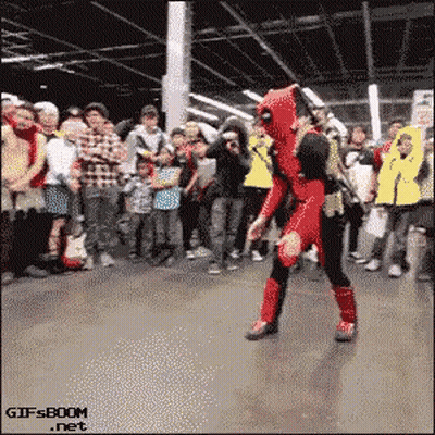 A Man In A Deadpool Costume Is Dancing In Front Of A Crowd .. GIF