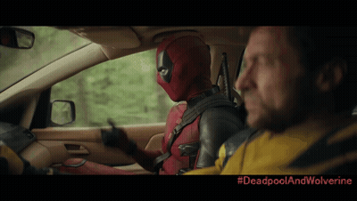 A Man In A Deadpool Costume Is Driving A Car Next To A Man In A Wolverine Jacket GIF
