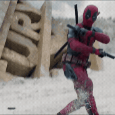 A Man In A Deadpool Costume Is Holding A Gun And A Sword In The Snow . GIF