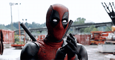 A Man In A Deadpool Costume Is Holding A Gun In His Hands . GIF