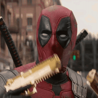 A Man In A Deadpool Costume Is Holding A Gun GIF