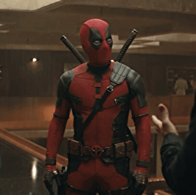 A Man In A Deadpool Costume Is Standing In A Room GIF