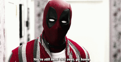 A Man In A Deadpool Costume Is Standing In A Room And Talking To Someone . GIF