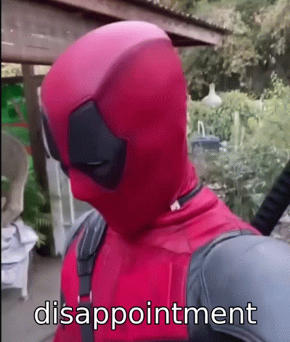 A Man In A Deadpool Costume Is Standing In Front Of A Fence With Disappointment Written On His Face . GIF
