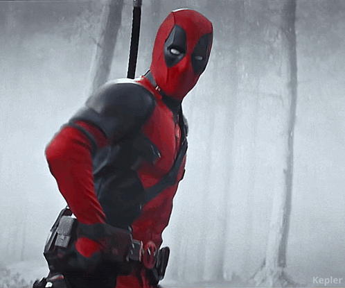 A Man In A Deadpool Costume Is Standing In The Woods GIF