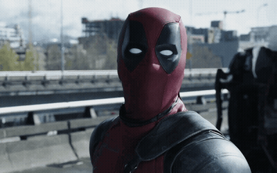 A Man In A Deadpool Costume Is Standing On A Highway GIF