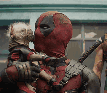 A Man In A Deadpool Costume Kisses A Small Dog GIF