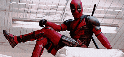 A Man In A Deadpool Costume Sits On A Rock GIF